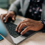 214324638-close-up-cropped-shot-of-unrecognizable-african-businessman-typing-on-laptop-at-home-office-web
